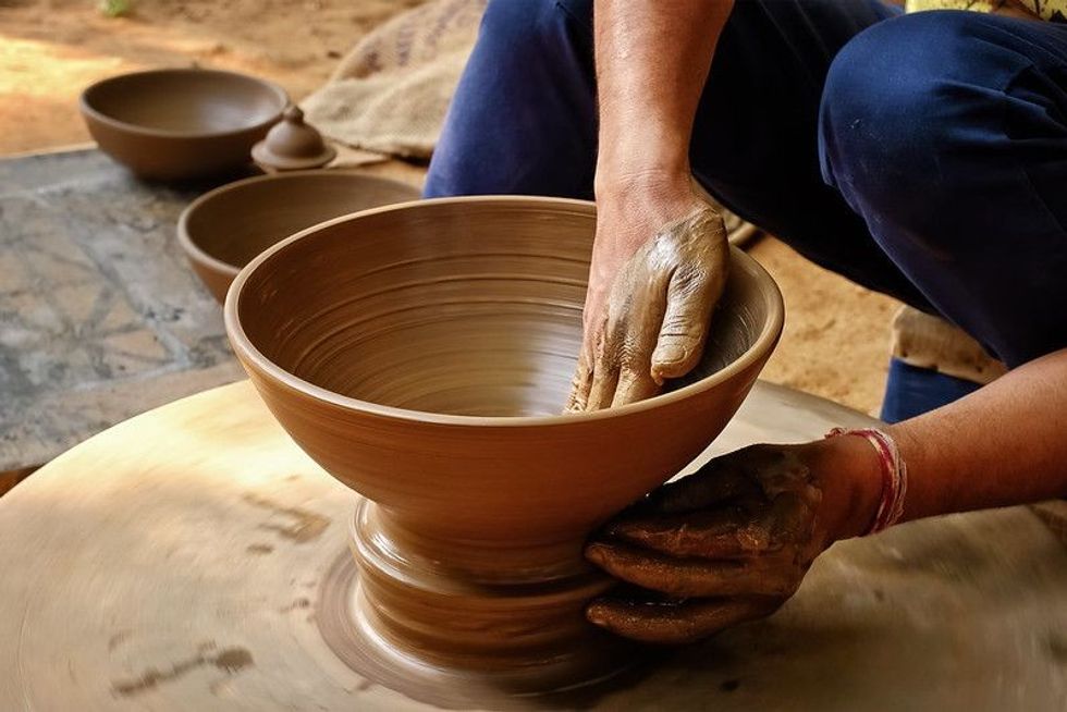 Potter is all muddy while doing pottery 