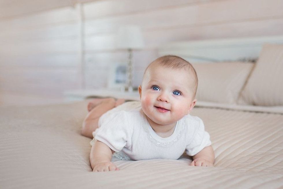 Pretty newborn lying and smiling on a bed