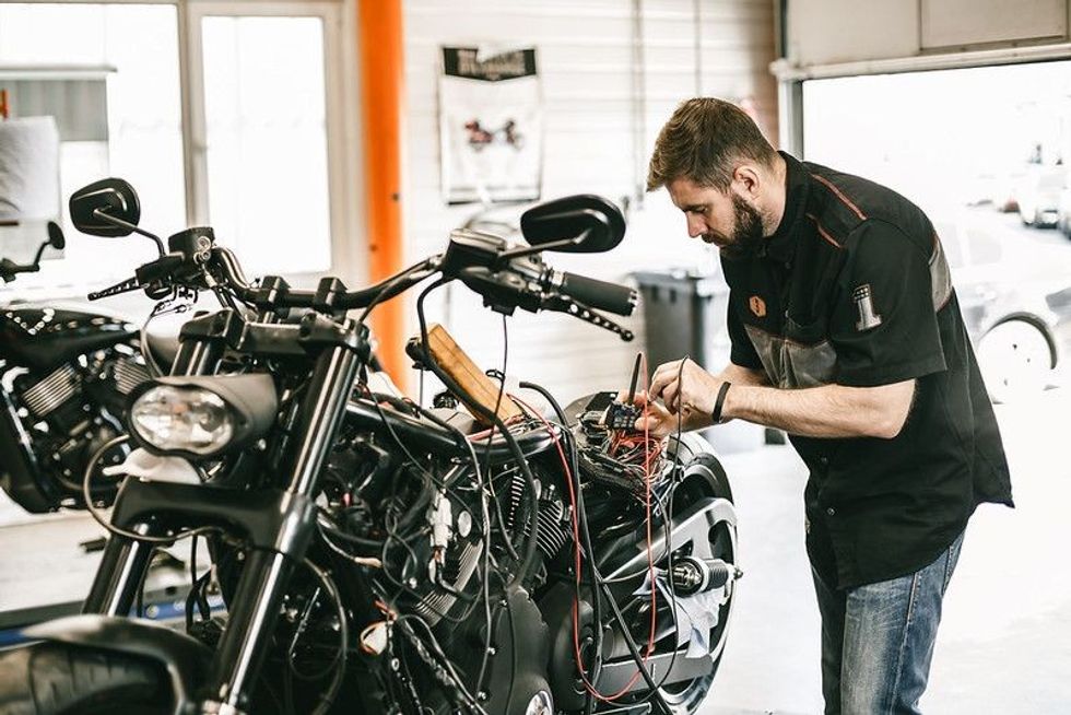 Professional motorcycle mechanic working on bike repair.