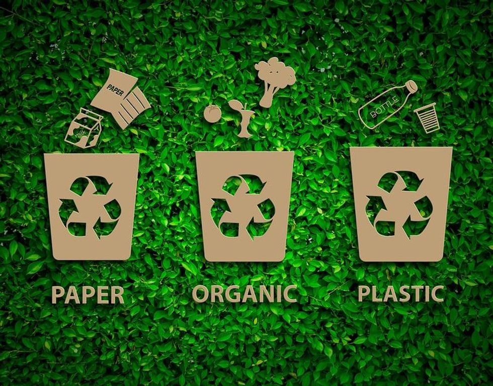 Recycling symbols on a green grass background.