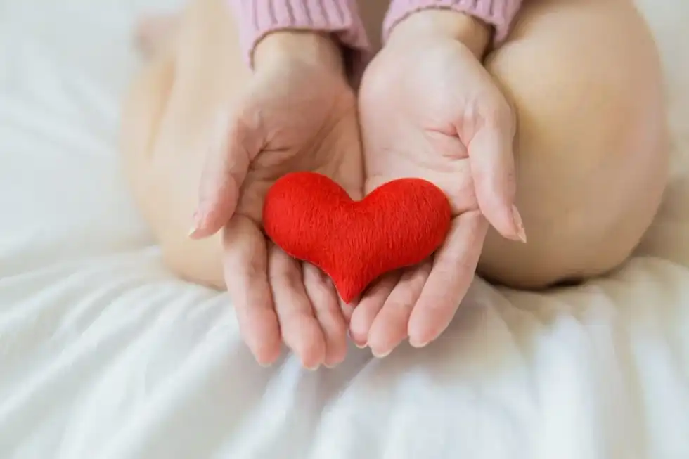 Red healing heart in a woman's hands