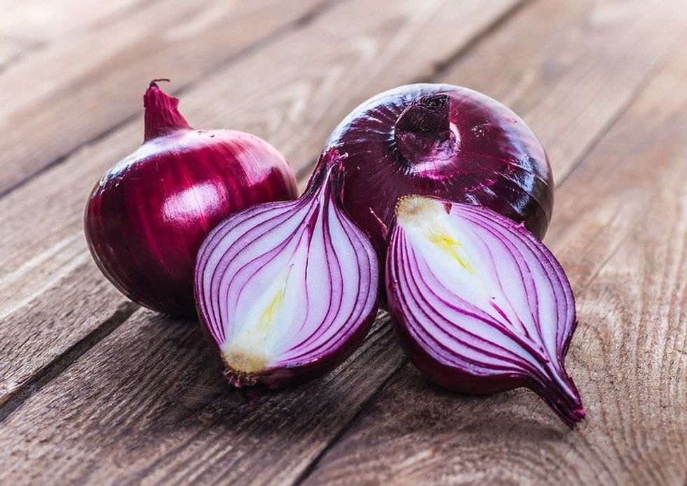 Red onions on rustic wood.