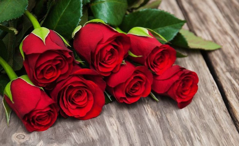 Red roses on a old wooden table