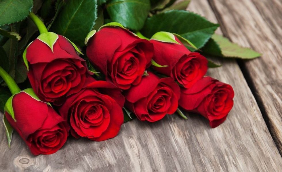 Red roses on a old wooden table