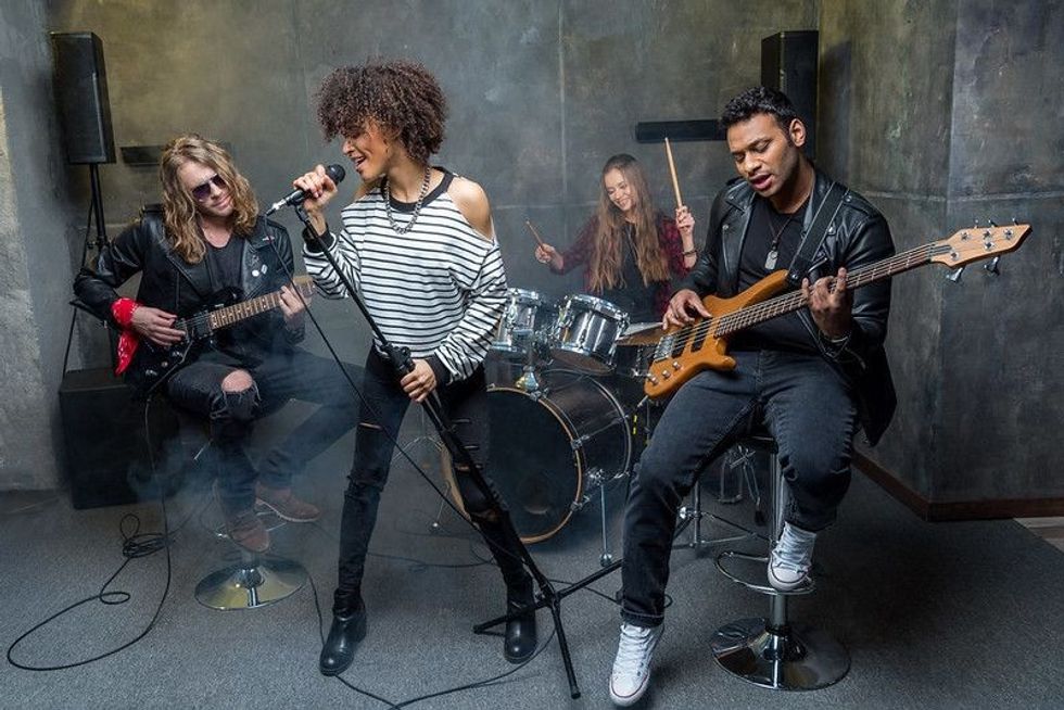 Rock musicians performing with their instruments.