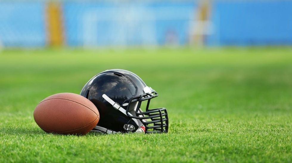 Rugby helmet with ball on field