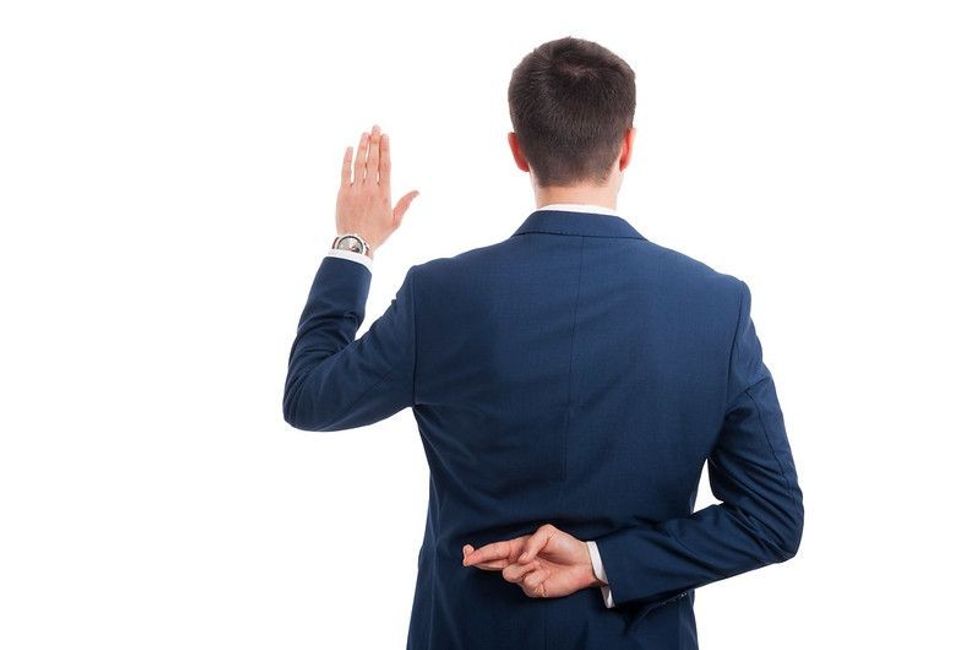 Salesman taking a fake oath with crossed fingers