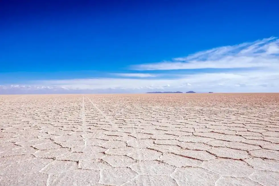 Salt flats in Bolivia with the bright blue sky above.