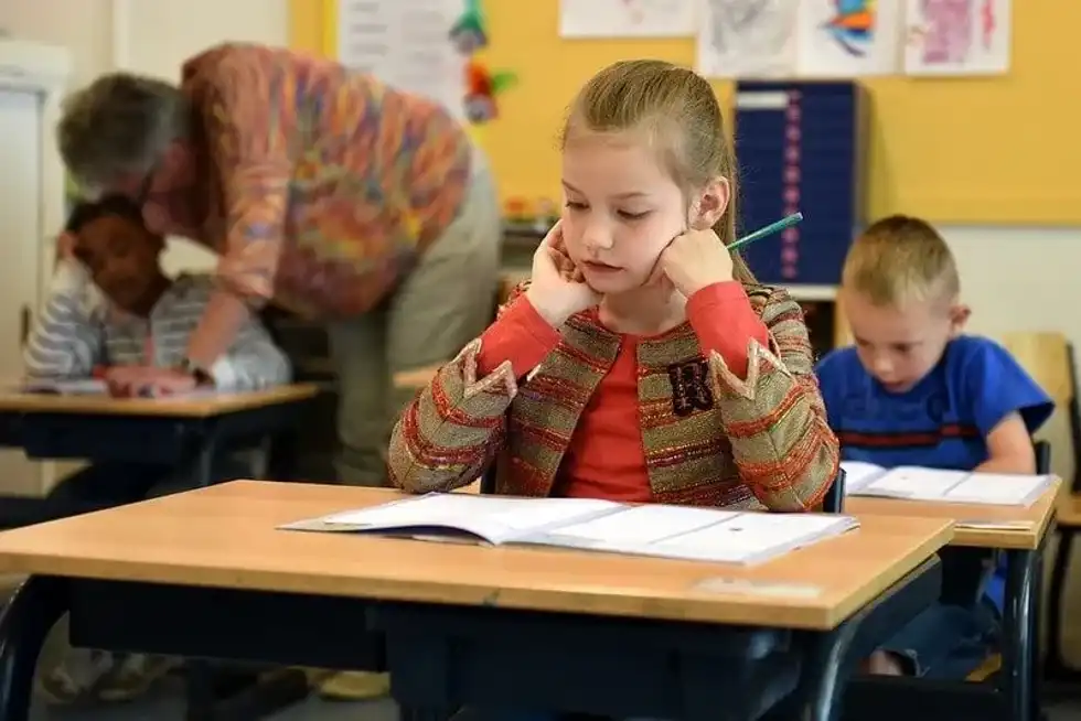 Schoolgirl sat at her desk sitting an exam.