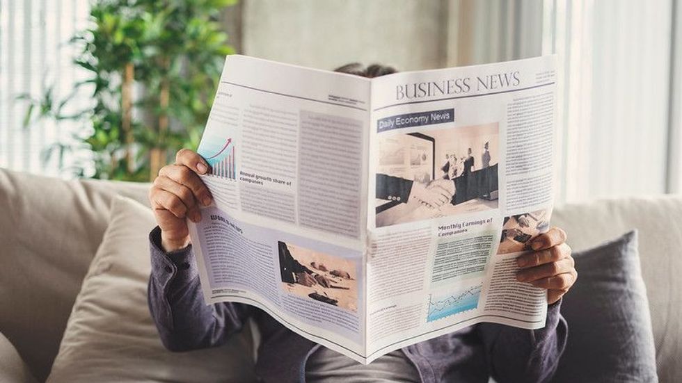 Senior man reading newspaper at home.