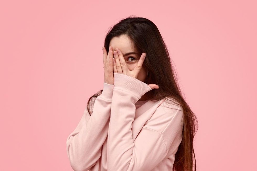 Shy woman hiding her face with her palm