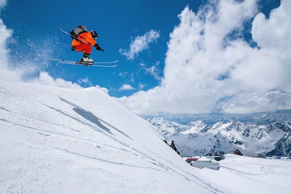 Skier midflight while ski jumping on the snowy mountain