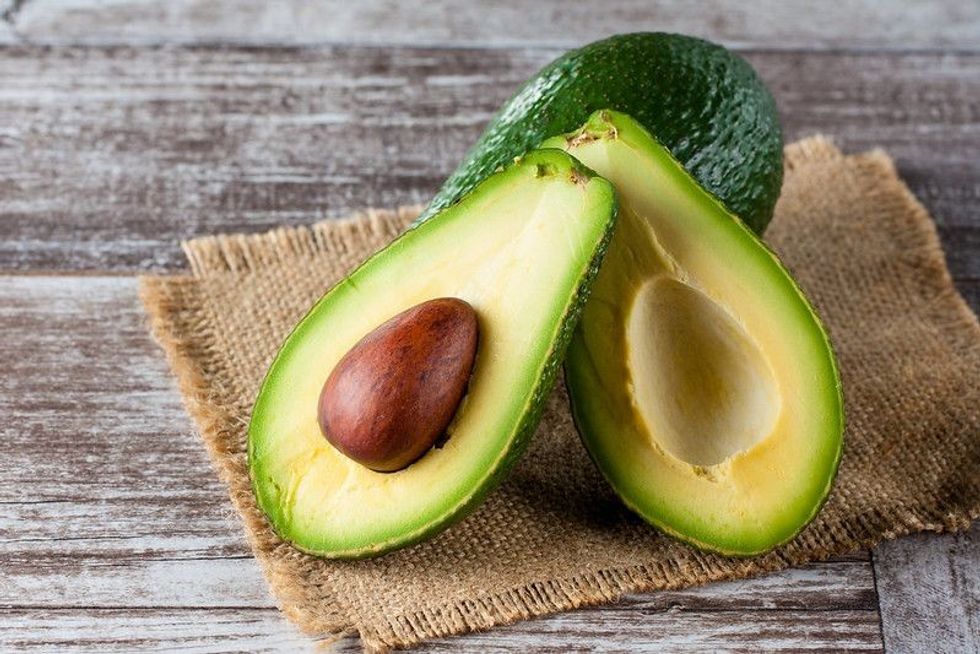 Sliced green avocados on table
