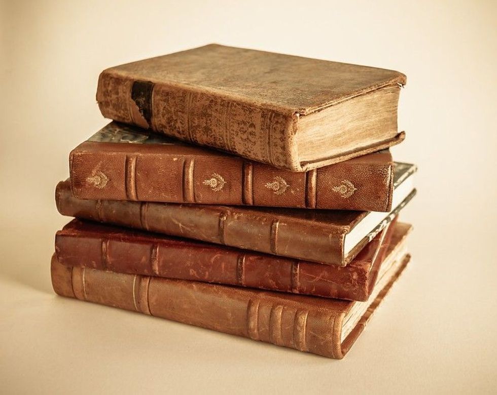 Stack of old books isolated on beige background.