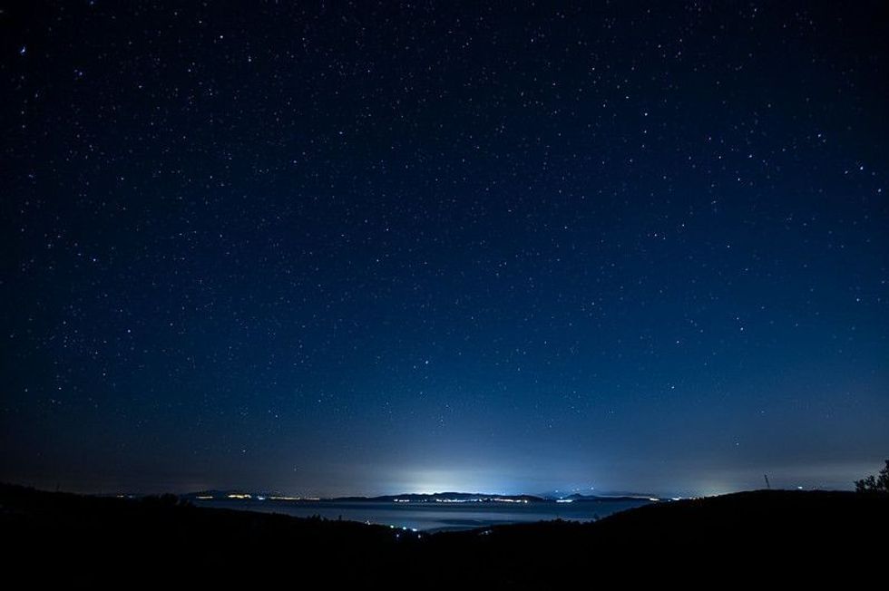 Starry night sky over city lights