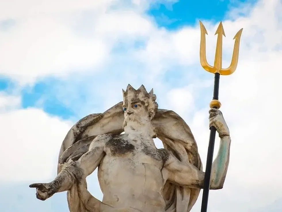 Statue of Neptune holding a golden trident in his hand.
