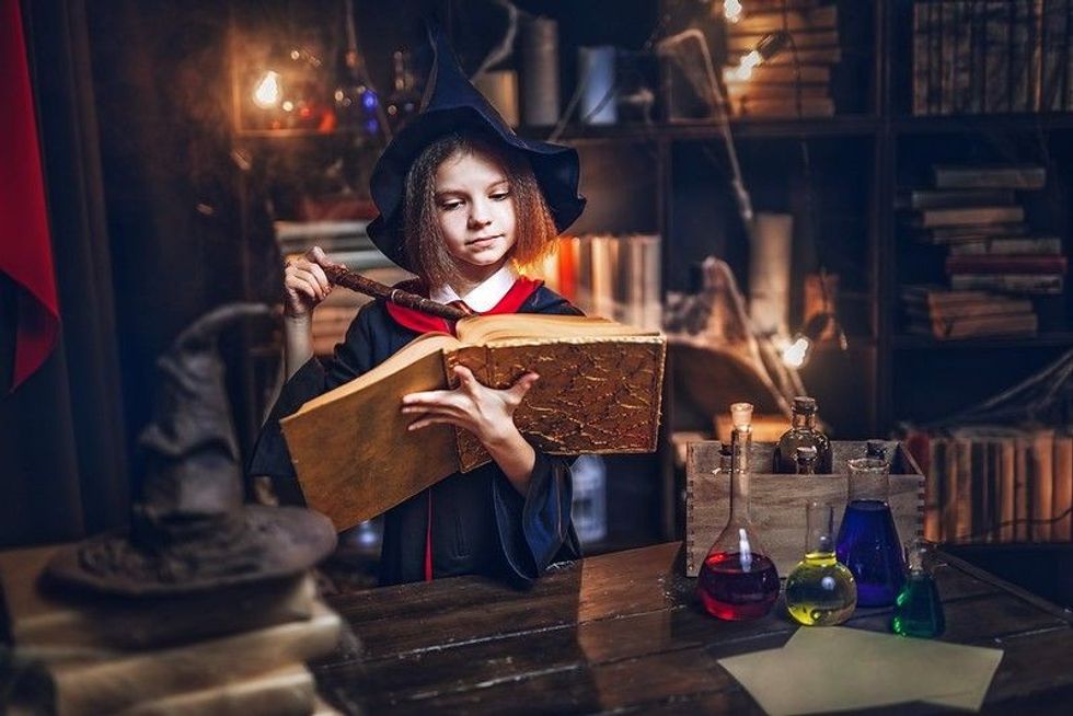 Surprised caucasian little girl in witch Cosplay