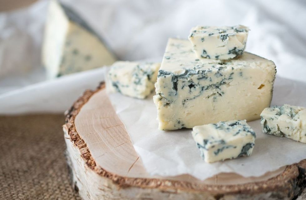 Tasty blue cheese on a wooden background
