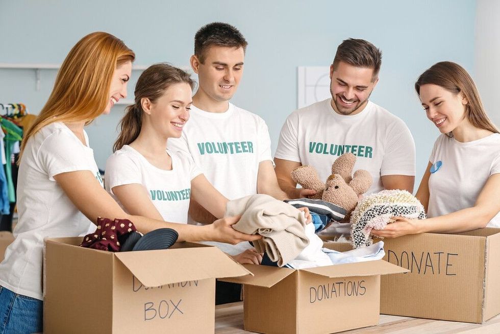 Team of volunteers with donations for poor people indoors.