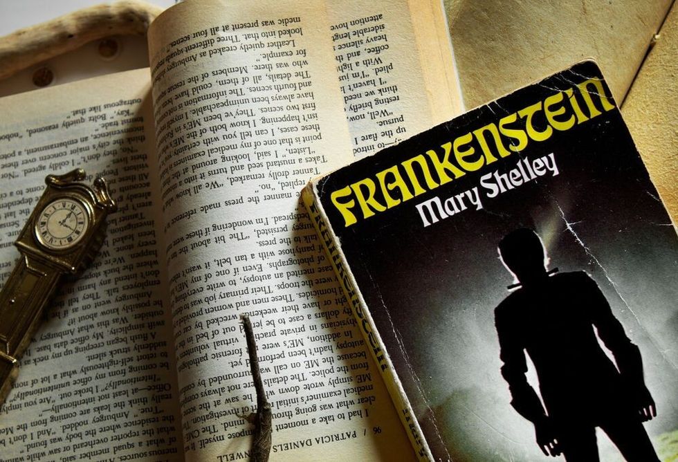 The book "Frankenstein" from Mary Shelley place next to other books and notebooks. Vintage vibe.
