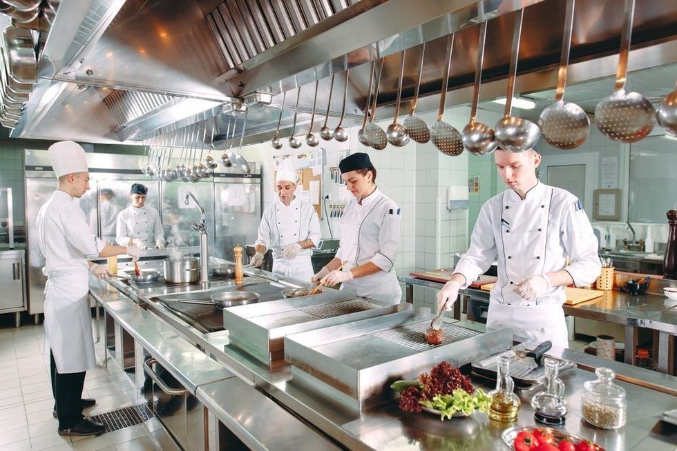The chefs prepare meals in the restaurant's kitchen.