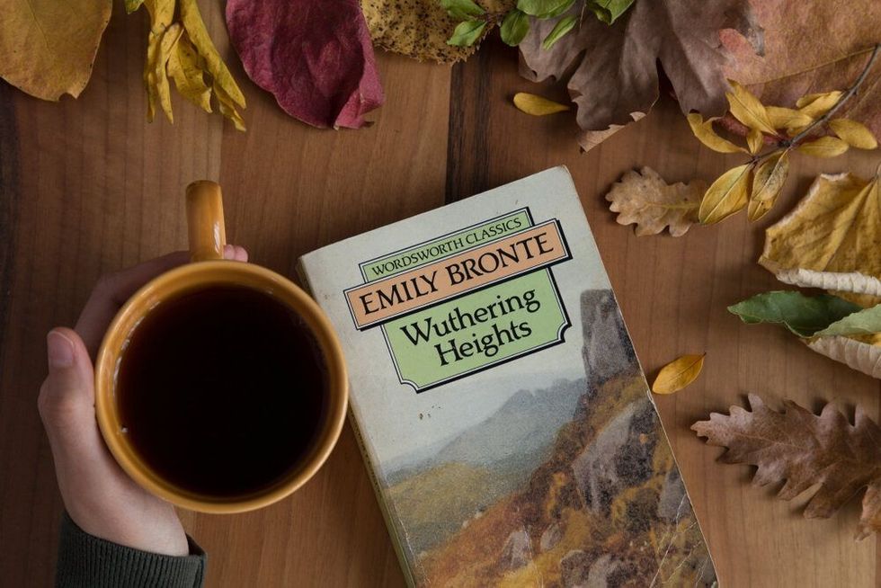  The cup of tea or coffee with Of Emily Bronte Wuthering Heights book on the wooden table.