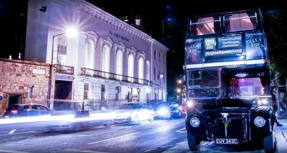 The Ghost Bus streaming through York streets at night.