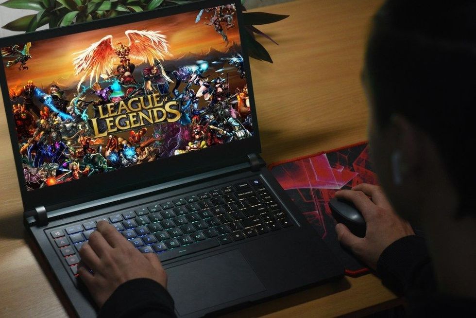 The guy plays on the notebook in League of Legends.