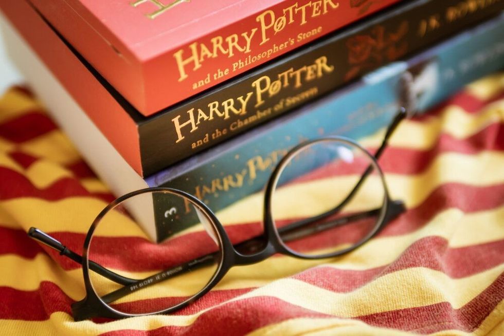 Three Harry Potter books stacked on eachother, with a round shaped pair of eyeglasses