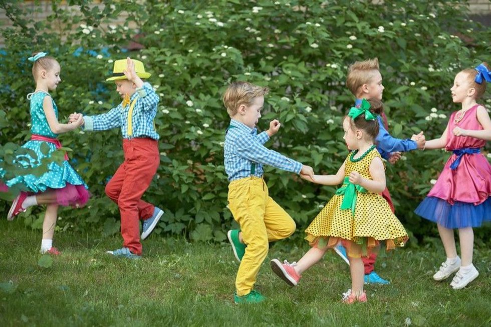 Three kids' couples dancing on lawn