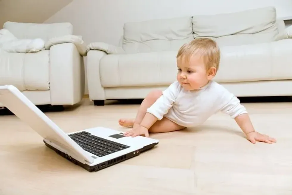 Toddler trying out an activity on a laptoop.