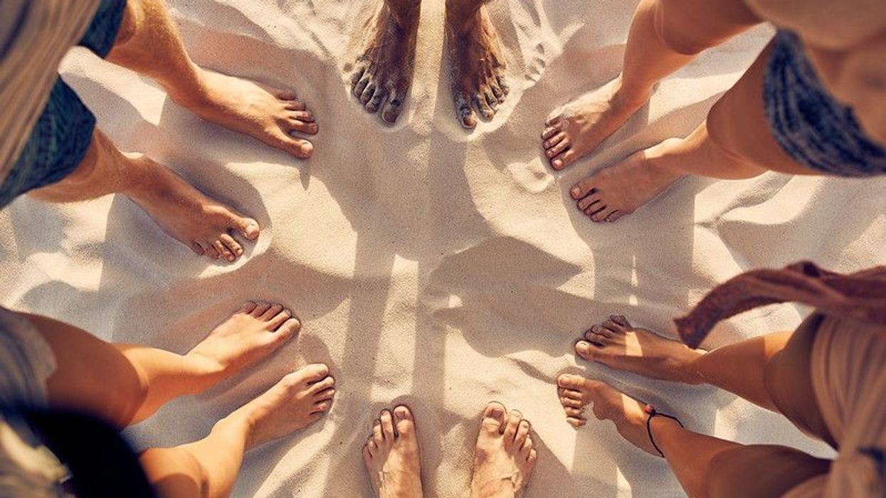 Top view image of feet of young people standing in a circle.