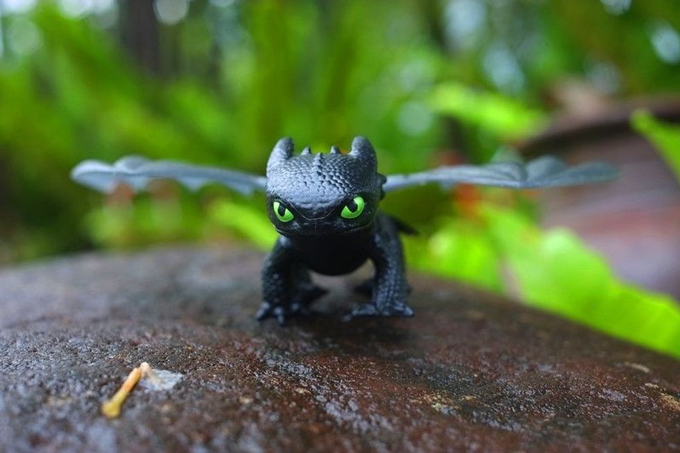 Toy figurine of Toothless (Night Fury) on a rock.