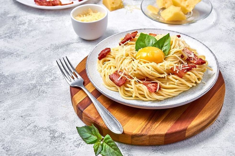 Traditional Italian Noodle Carbonara with bacon, cheese and egg yolk on plate