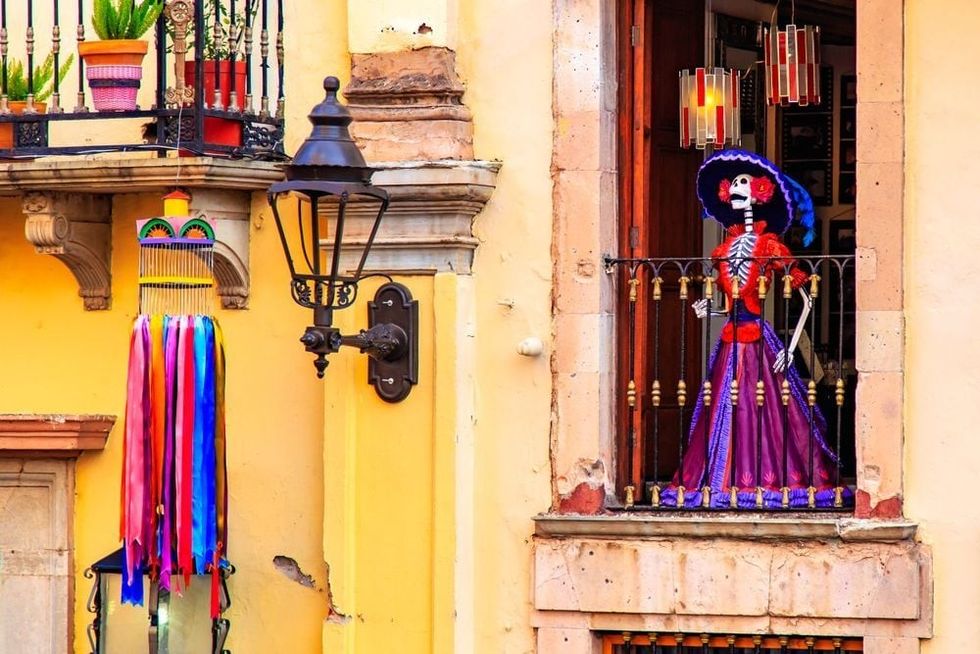 Traditional Mexican Catrina at the window of the old historic building.