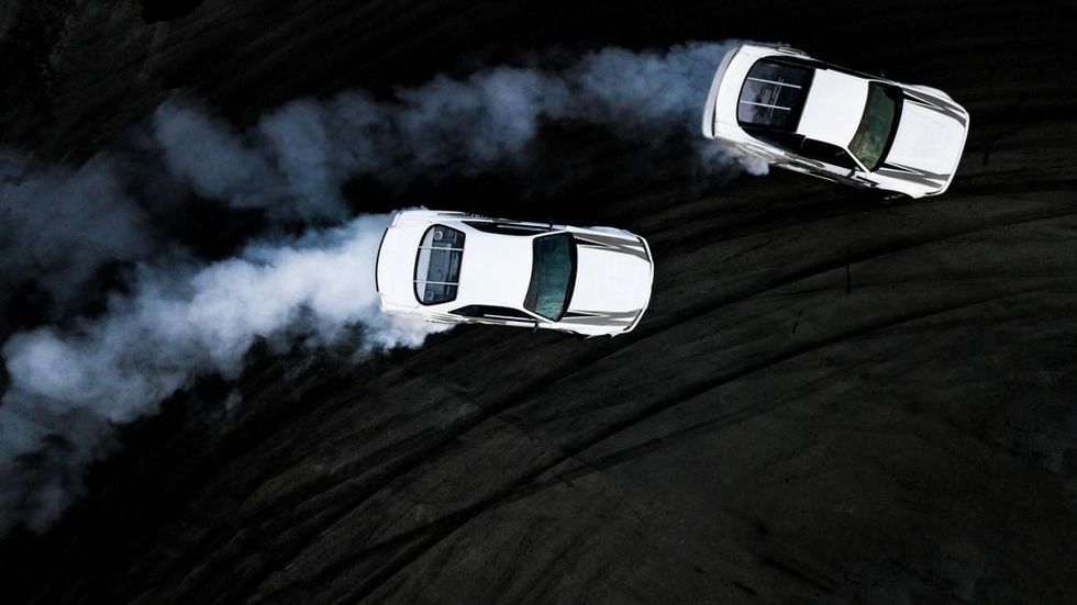 Two car drifting battle on asphalt street rad race track,