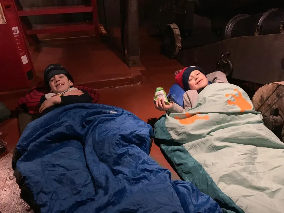 Two little boys enjoying a sleepover with smiles on their faces.