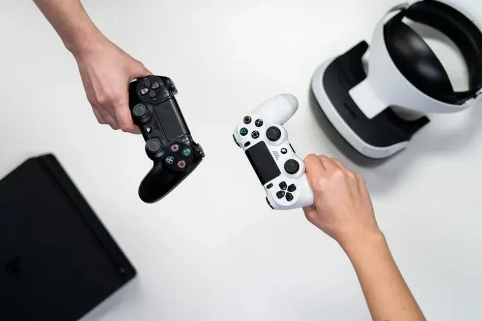 Two people holding video game controllers on white background