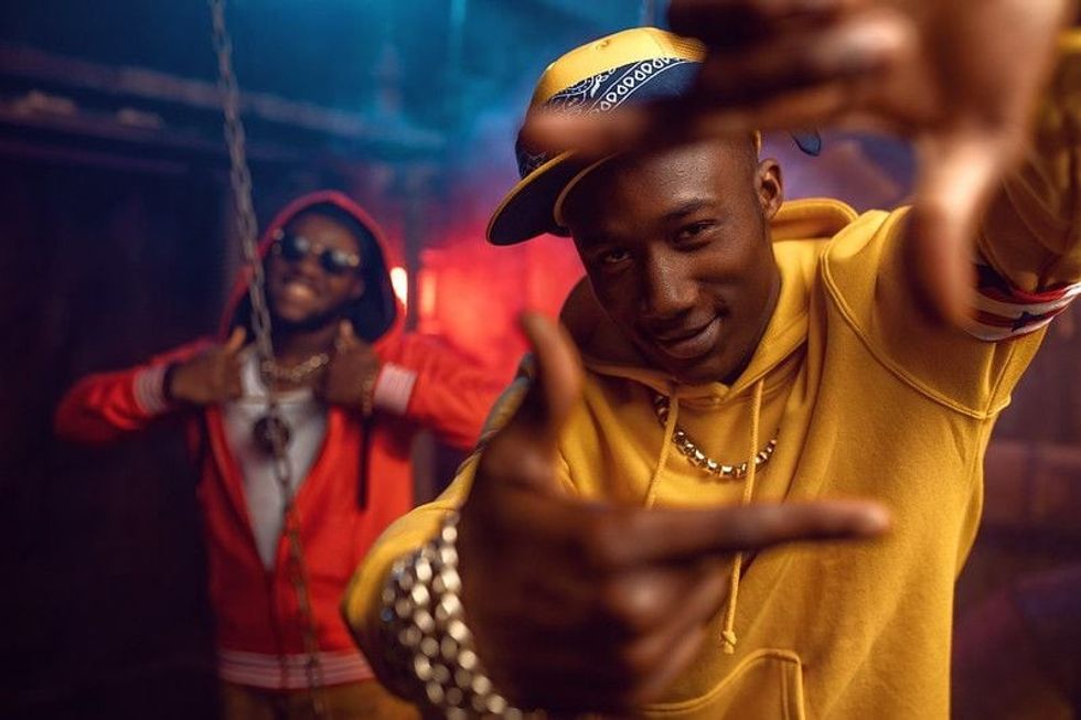 Two smiling rappers shooting a music video