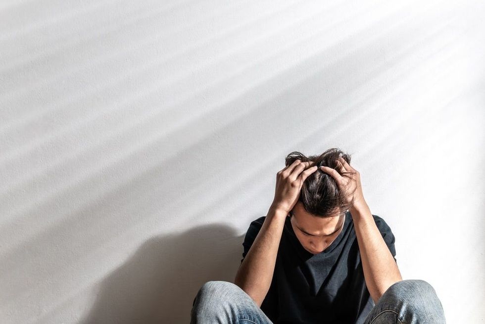 Upset Asian young man having problems.