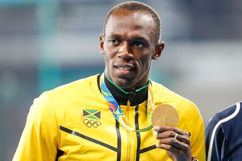 Usain Bolt posing with a gold medal