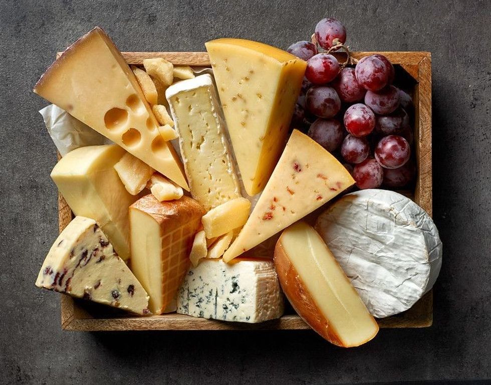 Various types of cheese on dark kitchen table