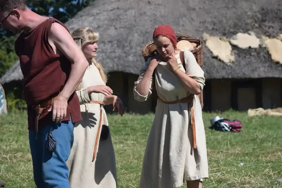 Viking woman carrying a load in a basket on her back.