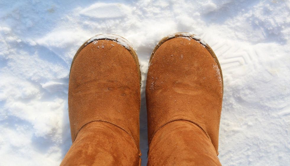 Warm brown ugg boots on snow.