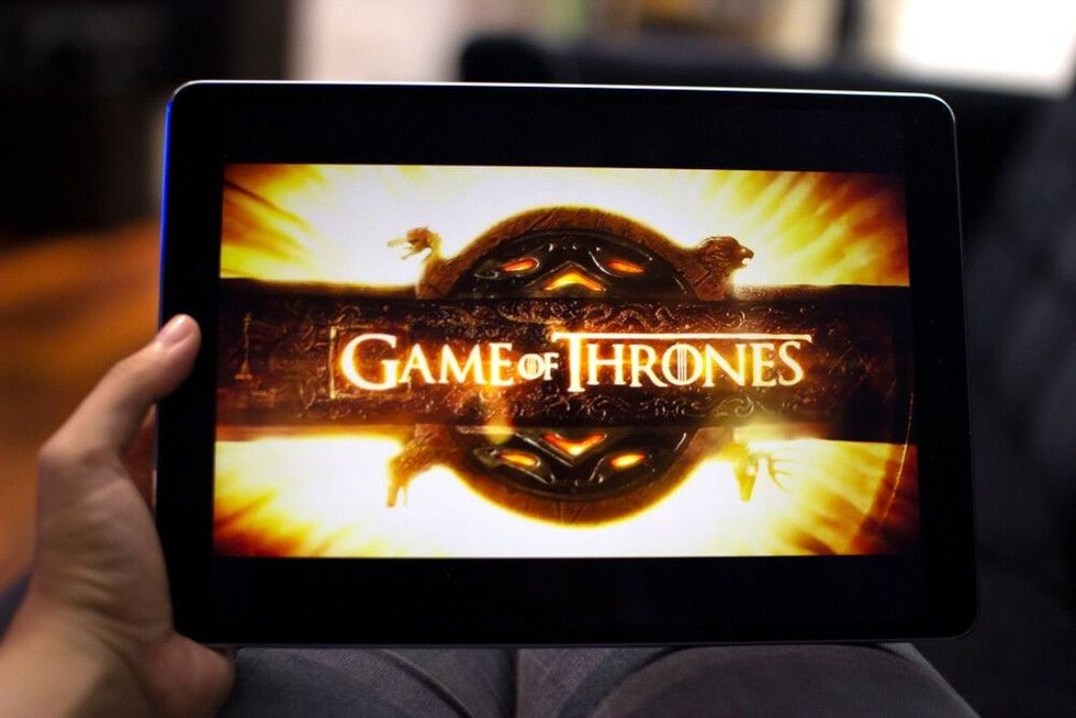 Watching Game of Thrones in a tablet, an HBO famous epic fantasy drama television series.
