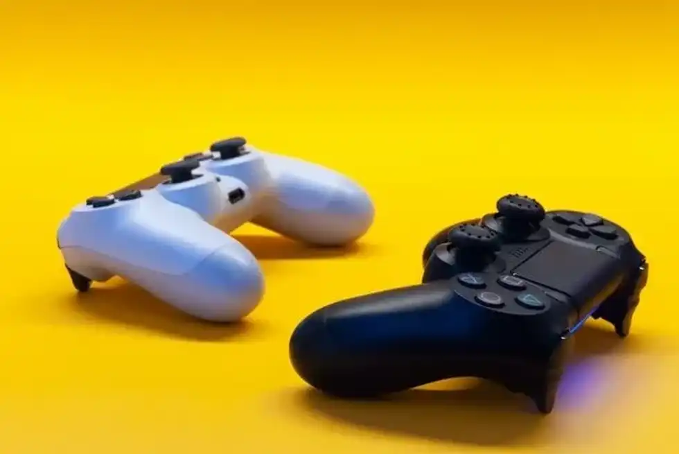 White and black game controllers on yellow background