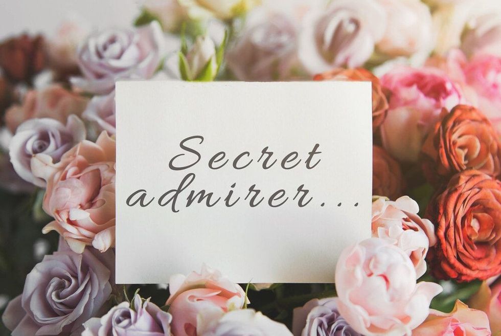 white card for a bouquet with the inscription secret admirer in a bright beautiful bouquet of flowers roses