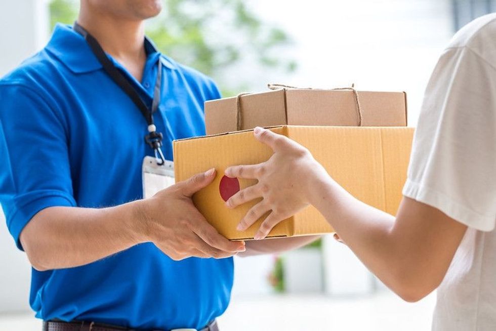Woman accepting a delivery of boxes from deliveryman