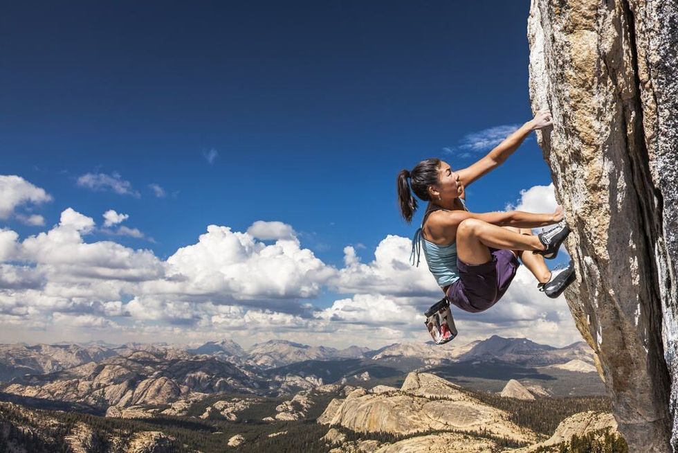 Woman climber climbing through a very difficult rock