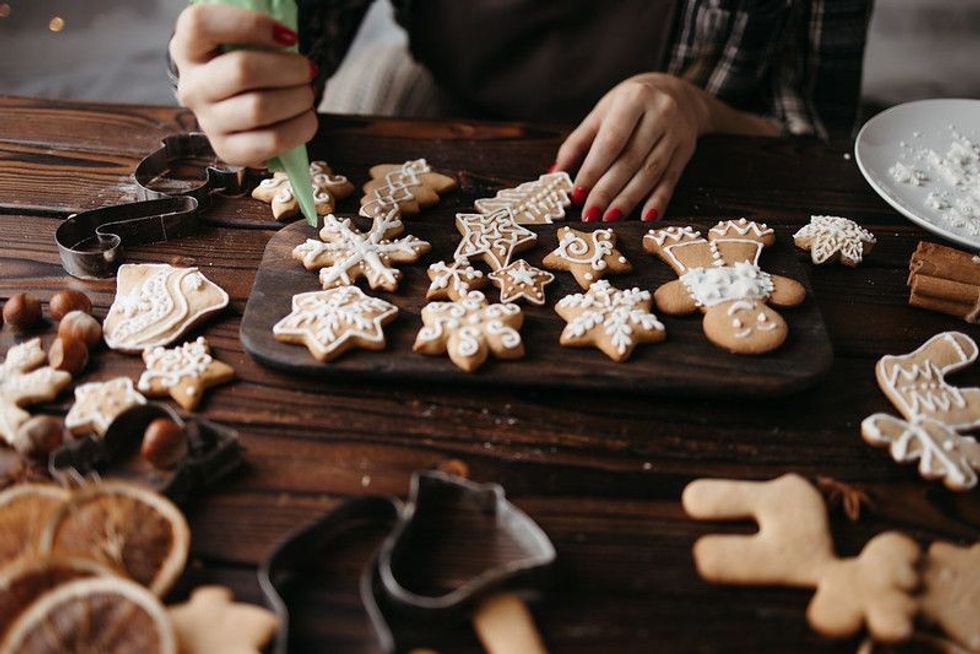 Woman decorating homemade gingerbread cookies.